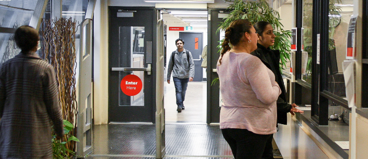 Students and faculty making their way through the library entrance on the 4th floor of Centennial Hall.