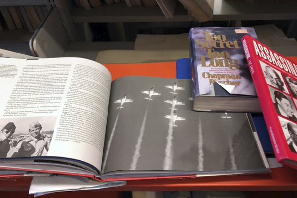 A books from the Intrepid collection, showing airplanes, lays open on a cart.