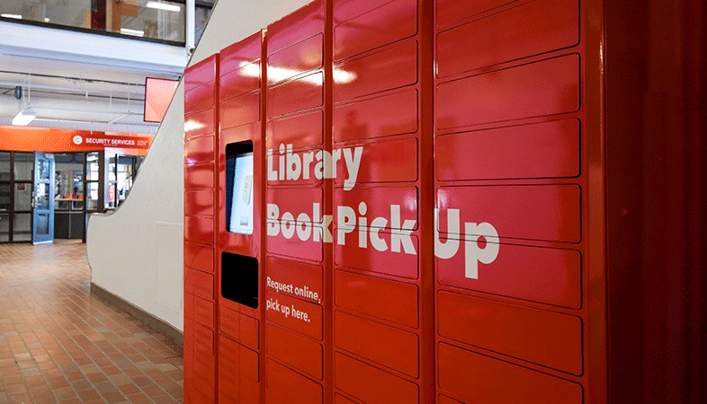 Big, bright red book lockers that say "Library Book Pickup."