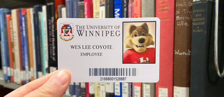 Wes Lee Coyote ID Card in front of books.